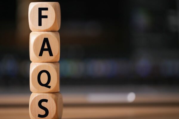 Four wooden blocks stacked on top of one another to spell 'FAQs'.